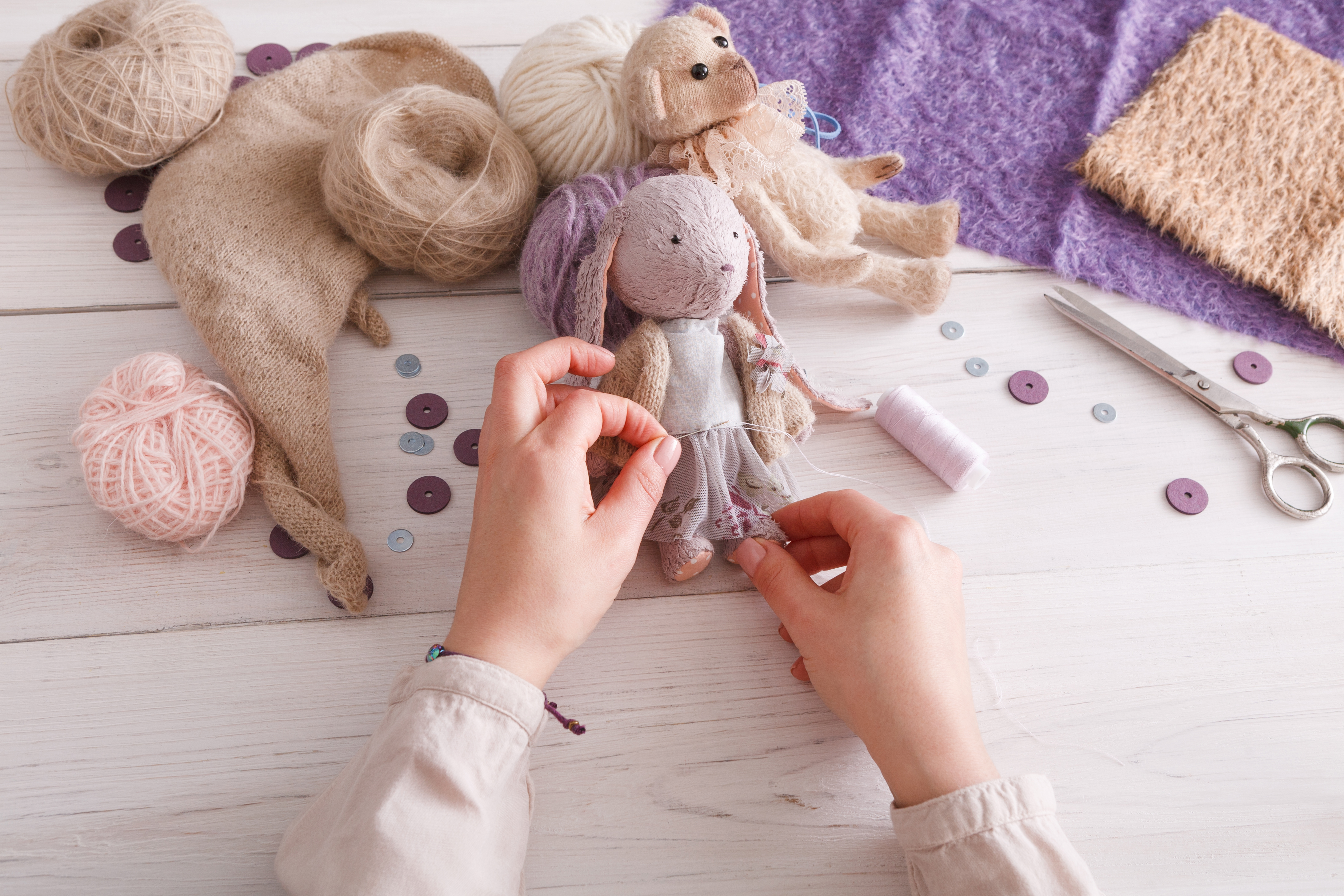 process-making-vintage-toy-top-view-artisan-pov-needlewoman-hands-sewing-handmade-rabbit-home-workshop.jpg